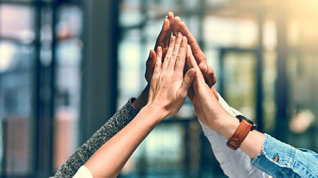 Logos and people collaborating around a table